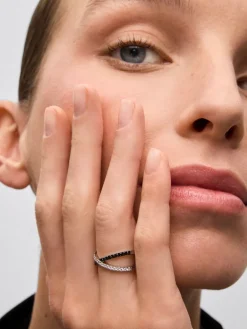 Anillo cruzado de oro blanco de 18K con 21 diamantes en talla brillante con un total de 0,25 cts y 18 diamantes negros en talla brillante con un total de 0,24 cts