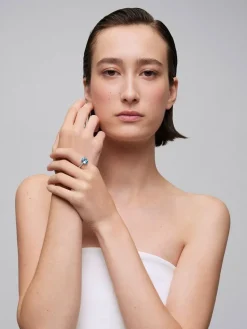 Anillo de oro amarillo de 18K con topacio azul sky en talla oval de 3,8 cts y diamantes en talla brillante