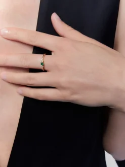 Anillo de oro amarillo de 18K con esmeralda en talla brillante de 0,1 cts y 7 diamantes en talla brillante con un total de 0,1 cts