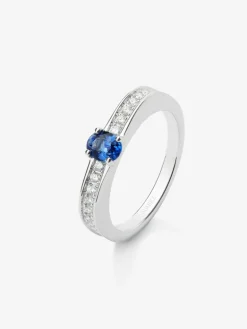 Anillo de oro blanco de 18K con zafiro azul en talla oval de 0,44 cts y 22 diamantes en talla brillante con un total de 0,15 cts