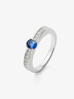 Anillo de oro blanco de 18K con zafiro azul en talla oval de 0,44 cts y 22 diamantes en talla brillante con un total de 0,16 cts