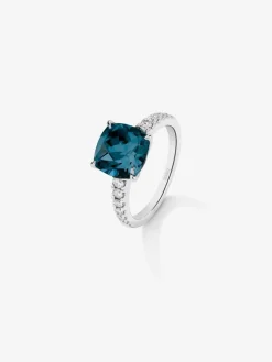 Anillo de oro blanco de 18K con topacio azul london en talla cushion de 3,8 cts y 12 diamantes en talla brillante con un total de 0,29 cts