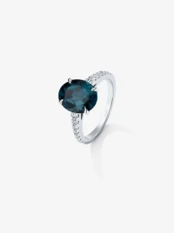 Anillo de oro blanco de 18K con topacio azul london en talla oval de 4,25 cts y 14 diamantes en talla brillante con un total de 0,32 cts