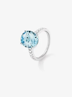 Anillo de oro blanco de 18K con topacio azul sky en talla oval de 5,8 cts y 12 diamantes en talla brillante con un total de 0,3 cts