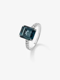 Anillo de oro blanco de 18K con topacio azul london en talla esmeralda de 4,25 cts y 14 diamantes en talla brillante con un total de 0,32 cts