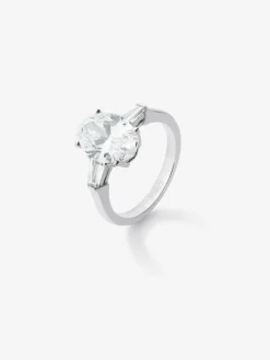 Anillo de oro blanco de 18K con diamante en talla oval de 3,01 cts y 2 diamantes en talla trapecio con un total de 0,49 cts