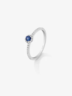 Anillo de oro blanco de 18K con zafiro azul en talla brillante de 0,15 cts y orla y brazo de 28 diamantes en talla brillante con un total de 0,2 cts