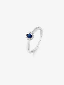 Anillo de oro blanco de 18K con zafiro azul en talla oval de 0,22 cts y 10 diamantes en talla brillante con un total de 0,08 cts