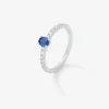 Anillo de oro blanco de 18K con zafiro azul en talla oval de 0,21 cts y 16 diamantes en talla brillante con un total de 0,2 cts