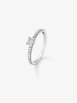 Anillo de oro blanco de 18K con diamante central en talla brillante de 0,12 cts y brazo de 20 diamantes en talla brillante con un total de 0,11 cts