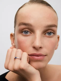 Anillo de oro blanco de 18K con zafiro azul en talla oval de 0,44 cts y 22 diamantes en talla brillante con un total de 0,16 cts