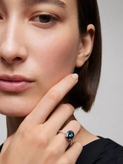 Anillo de oro blanco de 18K con topacio azul london en talla oval de 4,25 cts y 14 diamantes en talla brillante con un total de 0,32 cts