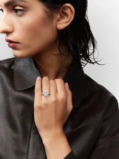 Anillo de oro blanco de 18K con diamante en talla marquise de 0,7 cts y orla y brazo de diamantes en talla brillante con un total de 0,63 cts
