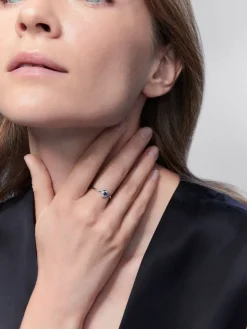Anillo de oro blanco de 18K con zafiro azul en talla brillante de 0,15 y 4 diamantes en talla brillante con un total de 0,08 cts