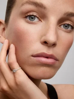 Anillo de oro blanco de 18K con diamante central en talla brillante en talla brillante de 0,06 cts y orla y brazo de 33 diamantes en talla brillante con un total de 0,18 cts