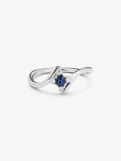 Anillo de oro blanco de 18K con zafiro azul en talla brillante de 0,15 y 4 diamantes en talla brillante con un total de 0,08 cts