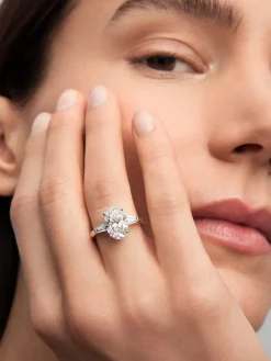 Anillo de oro blanco de 18K con diamante en talla oval de 3,01 cts y 2 diamantes en talla trapecio con un total de 0,49 cts