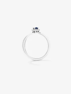 Anillo de oro blanco de 18K con zafiro azul en talla oval de 0,22 cts y 10 diamantes en talla brillante con un total de 0,08 cts