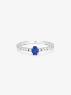 Anillo de oro blanco de 18K con zafiro azul en talla oval de 0,21 cts y 16 diamantes en talla brillante con un total de 0,2 cts