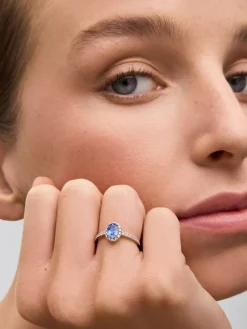 Anillo de oro blanco de 18K con zafiro azul en talla oval de 0,91 cts y orla de diamantes en talla brillante con un total de 0,37 cts