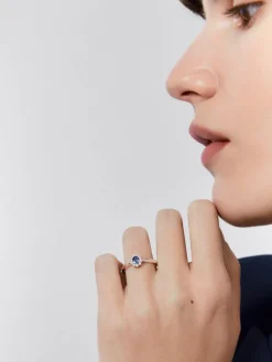 Anillo de oro blanco de 18K con zafiro azul en talla oval de 0,31 cts y diamantes en talla brillante con un total de 0,10 cts