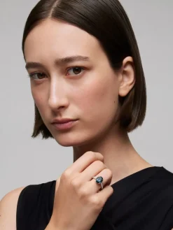 Anillo de oro blanco de 18K con topacio azul london en talla oval de 4,25 cts y 14 diamantes en talla brillante con un total de 0,32 cts