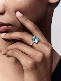 Anillo de oro blanco de 18K con topacio azul sky en talla esmeralda de 4,25 cts y diamantes blancos en talla brillante de 0,31 cts