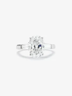 Anillo de oro blanco de 18K con diamante en talla oval de 3,01 cts y 2 diamantes en talla trapecio con un total de 0,49 cts