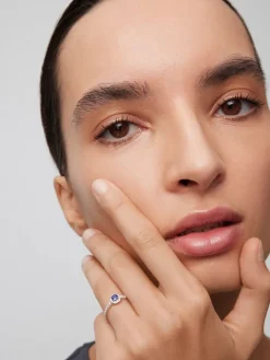 Anillo de oro blanco de 18K con zafiro azul en talla brillante de 0,35 cts y orla y brazo de 24 diamantes en talla brillante con un total de 0,32 cts