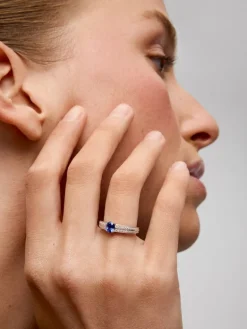 Anillo de oro blanco de 18K con zafiro azul vivid en talla oval de 1,292 cts y 32 diamantes en talla brillante con un total de 0,6 cts