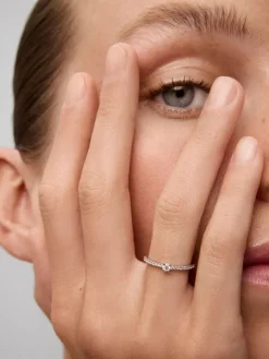 Anillo de oro blanco de 18K con diamante central en talla brillante de 0,12 cts y brazo de 20 diamantes en talla brillante con un total de 0,11 cts