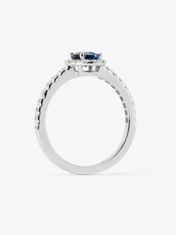 Anillo de oro blanco de 18K con zafiro azul en talla oval de 0,91 cts y orla de diamantes en talla brillante con un total de 0,37 cts
