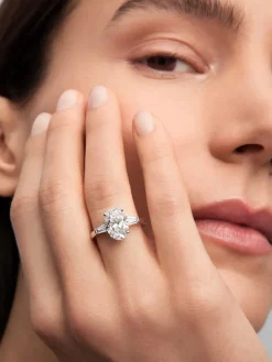 Anillo de oro blanco de 18K con diamante en talla oval de 3,01 cts y 2 diamantes en talla trapecio con un total de 0,49 cts