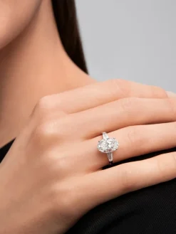 Anillo de oro blanco de 18K con diamante en talla oval de 3,01 cts y 2 diamantes en talla trapecio con un total de 0,49 cts