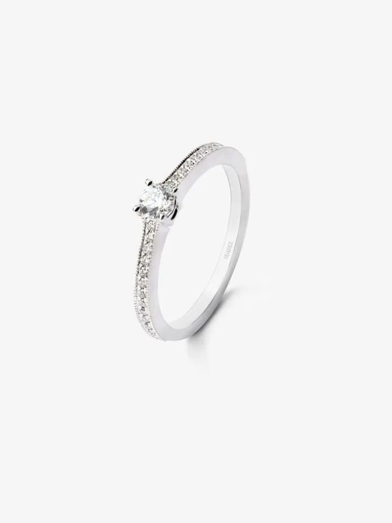 Anillo solitario de oro blanco de 18K con un diamante central en talla brillante de 0,23 cts y brazo de 29 diamantes en talla brillante con un total de 0,12 cts