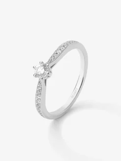 Anillo solitario de oro blanco de 18K con diamante central en talla brillante de 0,20 cts y diamantes en talla brillante con un total de 0,09 cts