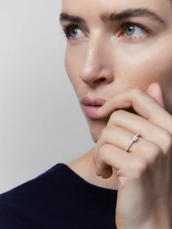 Anillo solitario de oro blanco de 18K con diamante central en talla esmeralda de 0,3 cts y 26 diamantes en talla brillante con un total de 0,13 cts