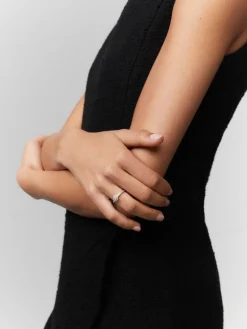 Anillo solitario de oro blanco de 18K con diamante central en talla brillante de 0,15 cts y orla y brazo con 30 diamantes en talla brillante con un total de 0,28 cts