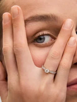 Anillo solitario de oro blanco de 18K con diamante central en talla brillante de 0,50 cts y diamantes en talla brillante con un total de 0,23 cts
