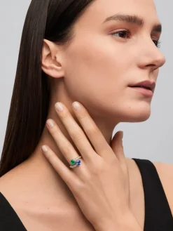 Anillo tú y yo de oro blanco de 18K con zafiro azul intenso en talla pera de 1,93 cts, esmeralda verde en talla pera de 0,89 cts y 14 diamantes en talla brillante con un total de 0,89 cts