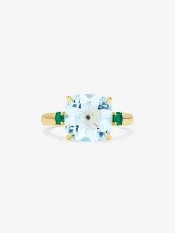 Anillo tresillo de oro amarillo de 18K con topacio azul sky en talla cushion de 4,88 cts y 2 esmeraldas verdes en talla brillante