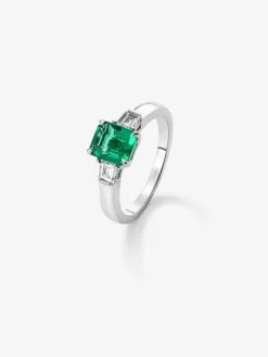 Anillo tresillo de oro blanco de 18K con esmeralda verde vivid en talla esmeralda de 1,64 cts y 2 diamantes blancos en talla fantas&iacute;a con un total de 0,4 cts