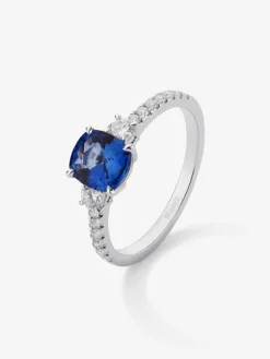Anillo tresillo de oro blanco de 18K con zafiro azul royal en talla cushion de 1,15 cts y diamantes en talla brillante con un total de 0,37 cts