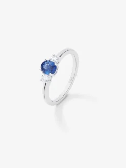 Anillo tresillo de oro blanco de 18K con zafiro azul en talla oval de 0,48 cts y 2 diamantes en talla brillante con un total de 0,24 cts