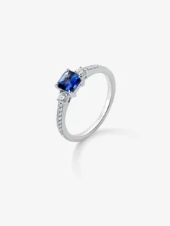 Anillo tresillo de oro blanco de 18K con zafiro azul en talla octogonal de 0,7 cts y 2 diamantes en talla brillante con un total de 0,26 cts