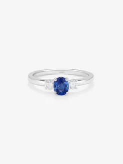 Anillo tresillo de oro blanco de 18K con zafiro azul en talla oval de 0,48 cts y 2 diamantes en talla brillante con un total de 0,24 cts