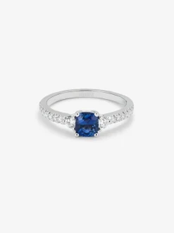 Anillo tresillo de oro blanco de 18K con zafiro azul cornflower en talla cushion de 1,09 cts y 16 diamantes en talla brillante con un total de 0,28 cts