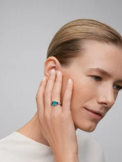 Anillo tresillo de oro blanco de 18K con esmeralda verde en talla octogonal de 1,58 cts, zafiros azules en talla octogonal de 1,28 cts y diamantes blancos en talla brillante de 0,2 cts