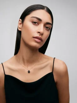 Colgante de oro amarillo de 18K con ónix negro de 1,45 cts y diamante blanco en talla esmeralda de 0,1 cts