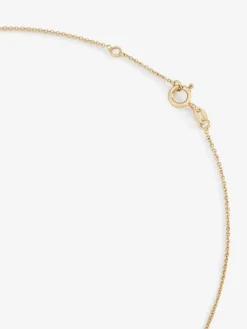 Colgante de oro amarillo de 18K con cruz mediana y diamante en talla brillante de 0,01 cts